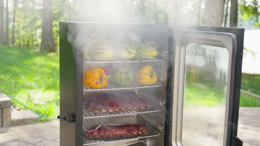 Smoke pours out of an open 710 WiFi digital smoker filled with racks of ribs, whole bell peppers, and husk-on corn on the cob.