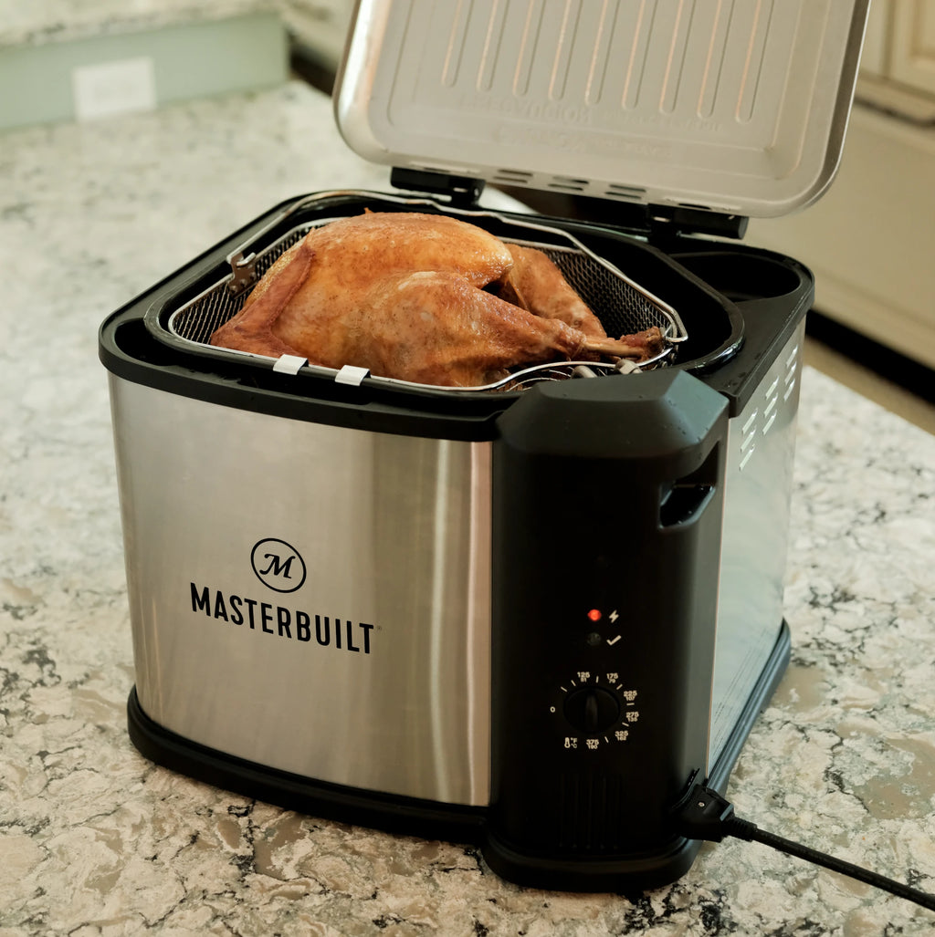 A golden-brown turkey drains in the fryer basket held up by the patented drain clips