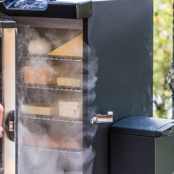 4 racks of cheese and fish in a smoker with the slow smoker attached